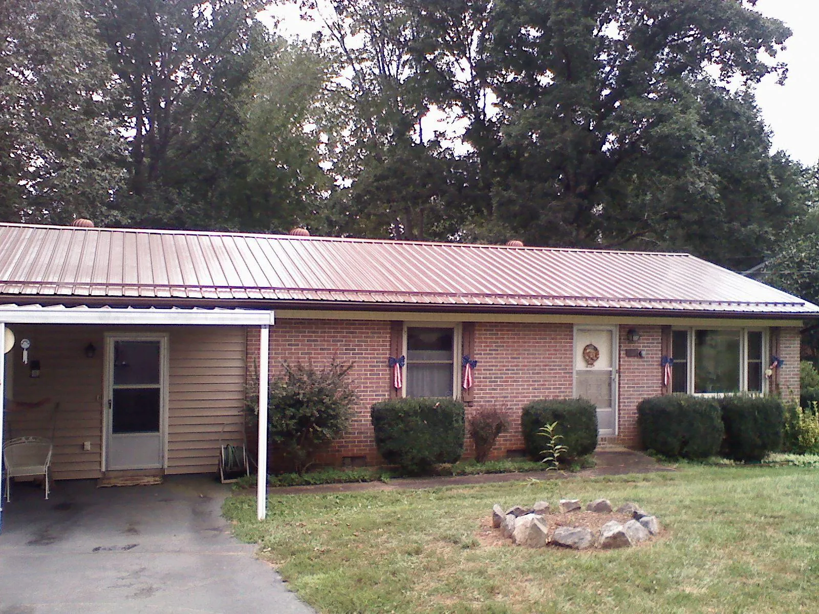 Bronze metal roof and carport on a brick ranch home — Roof Repair work by our crew in Brandon